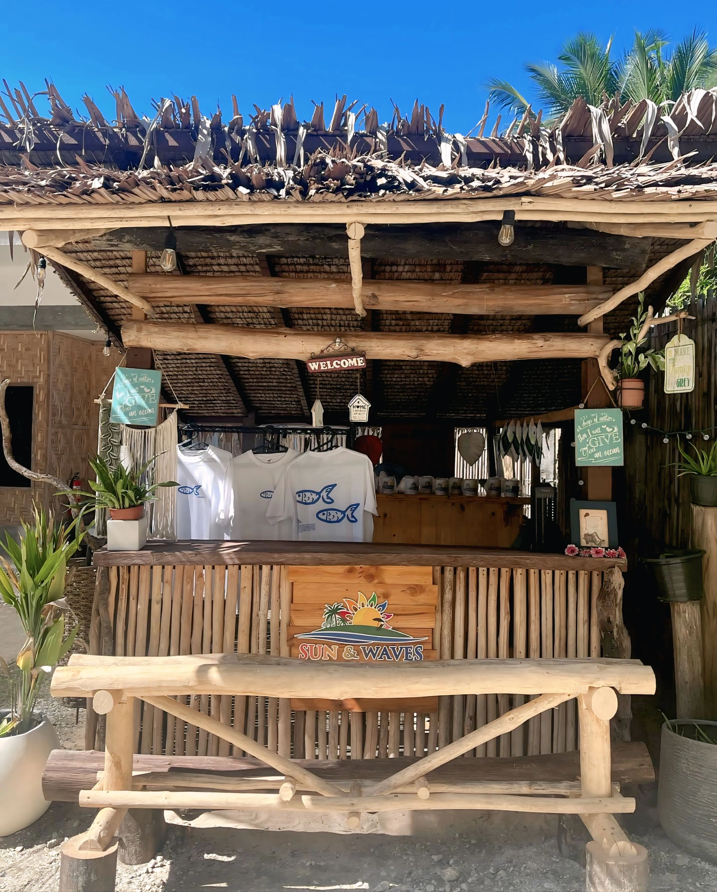 Sun & Waves Resort shop with bamboo counter, merchandise, and welcome sign.