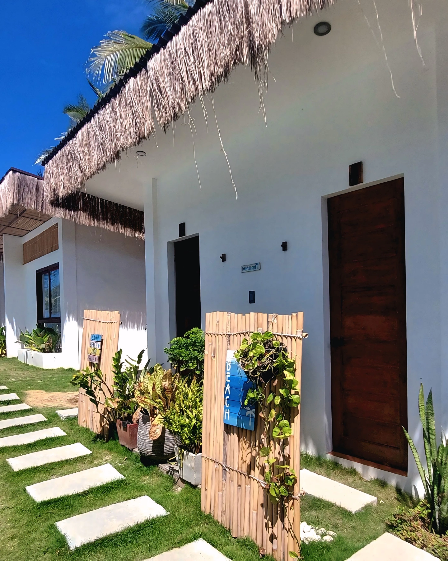 About Sun and Waves Resort with beach sign and tropical plants